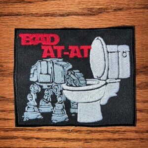 Comical embroidered patch featuring an At-At animal like drinking from toilet